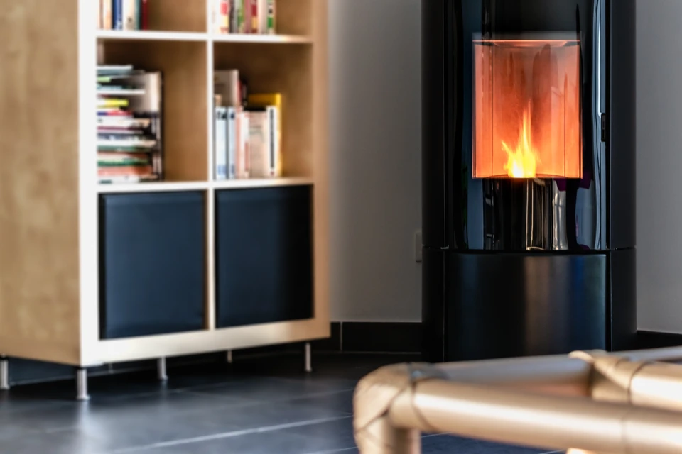 Intérieur résidentiel avec poêle à granulés moderne en fonctionnement, flammes visibles dans le foyer vitré