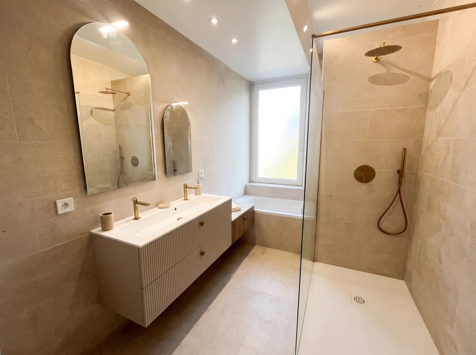 Salle de bain moderne avec vasque en pierre naturelle grise posée sur plan de travail en bois suspendu